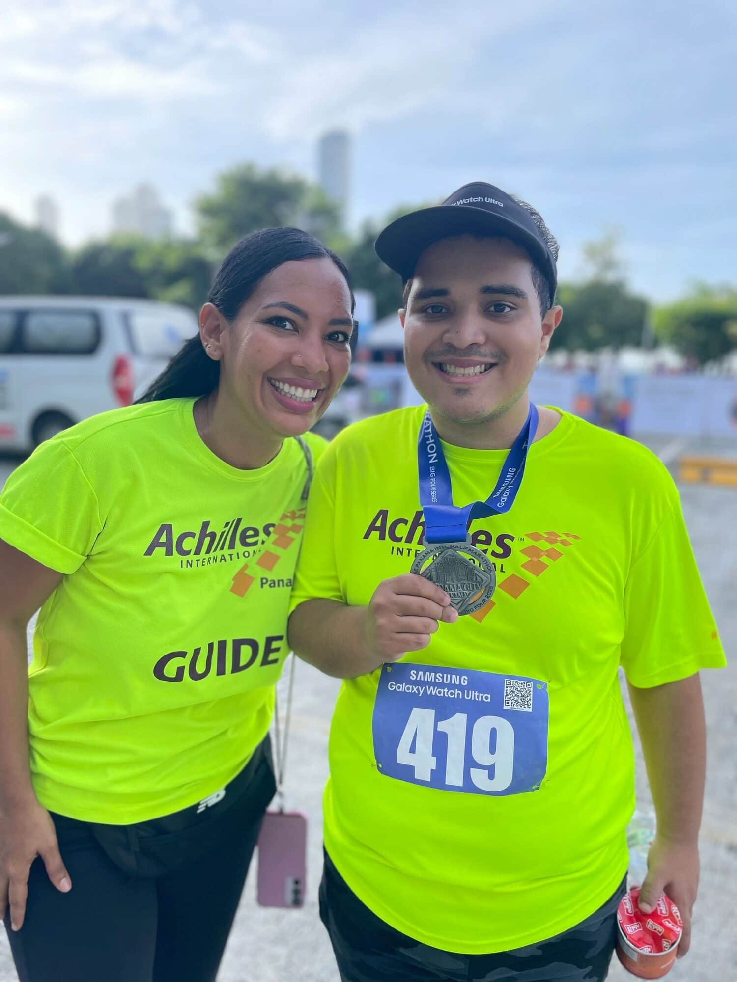 Una guía y un atleta muestran su medalla